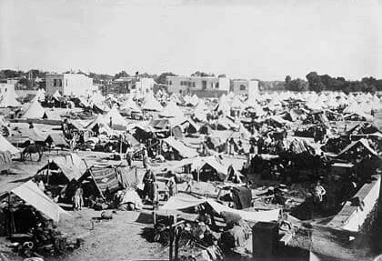A sprawling 19th-century style refugee camp with hundreds of canvas tents, used as visual research for the logistics of exile and historical displacement in the 1870s.