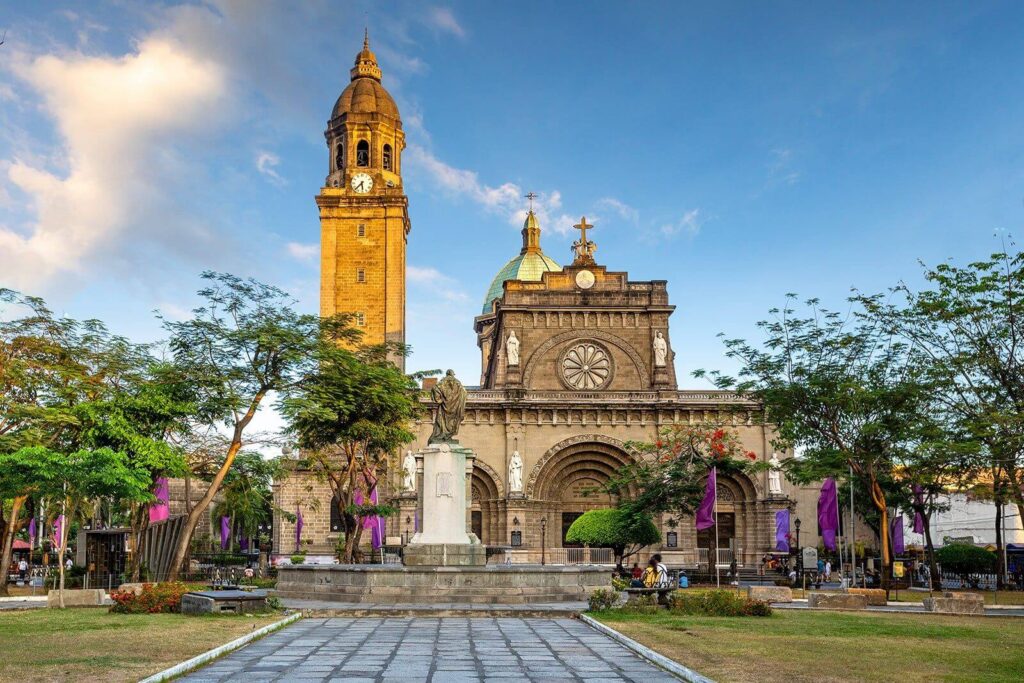 Facade of Manila Cathedral in Intramuros with bell tower, central dome, and plaza in front