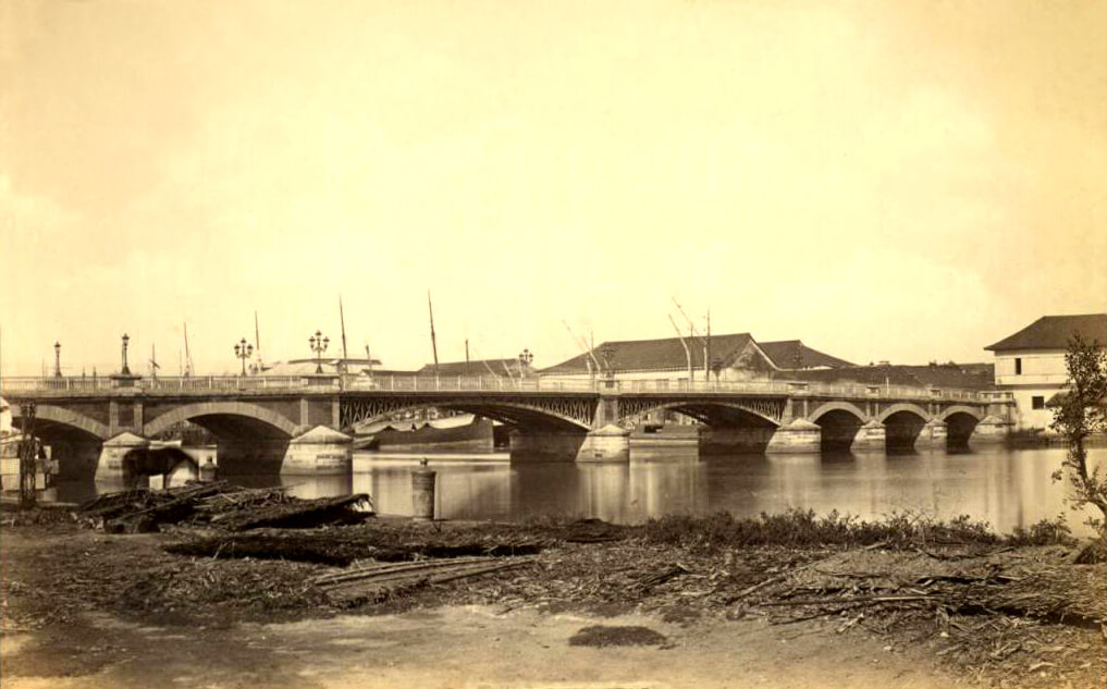 Historic Puente Grande bridge spanning the Pasig River with stone arches and early Manila waterfront